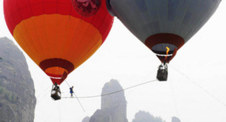 Китайский акробат прошел по канату, натянутому между двух воздушных шаров