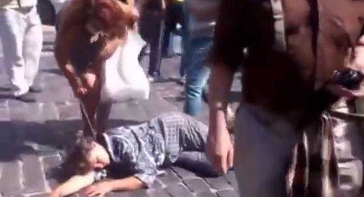 На Майдане женщина с битой сорвала цепочку с лежащего человека (видео)