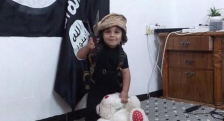 Ребенок обезглавил игрушку на фоне флага ИГИЛа: шокирующее видео