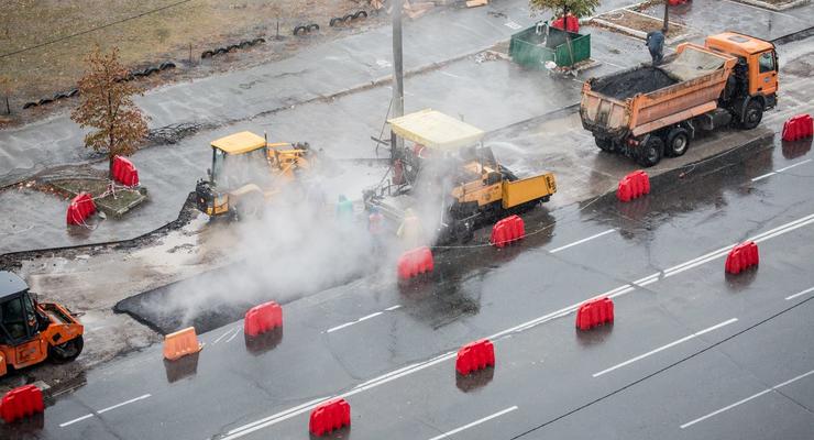 Хоть камни с неба: В Киеве коммунальщики кладут асфальт несмотря на дождь