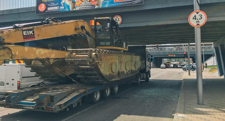 В Киеве под мостом на Левобережке застрял грузовик с экскаватором
