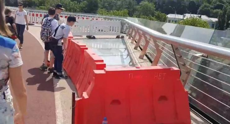 В Киеве новые стекла на пешеходном мосту оградили забором от пешеходов