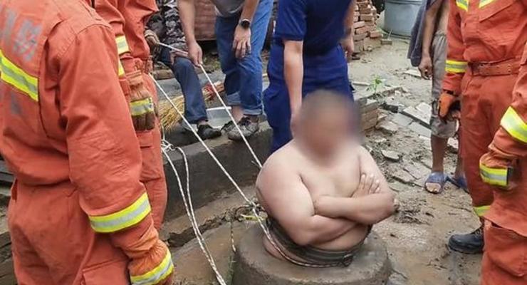 В Китае полный мужчина прыгнул в колодец и застрял