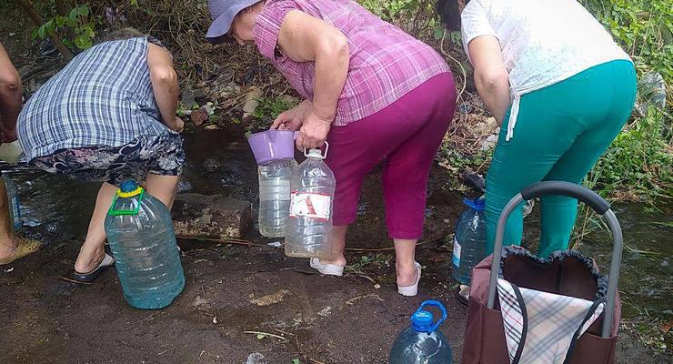 Жителі Маріуполя вимушені набирати воду з калюж: фото